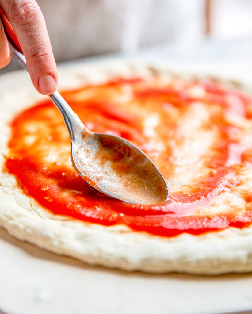 Passierte San Marzano auf Pizzateig geben